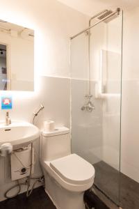 a bathroom with a toilet and a sink and a shower at Homey and Cozey Poblacion Makati S02 in Manila +8 photos