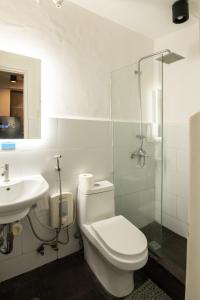 a bathroom with a toilet and a sink and a shower at Homey and Cozey Poblacion Makati S02 in Manila