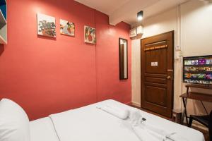 a red room with a white bed and a door at Homey and Cozey Poblacion Makati S02 in Manila