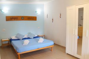 une chambre avec un lit bleu avec des serviettes dessus dans l'établissement S’alba Noa, à Quartu SantʼElena