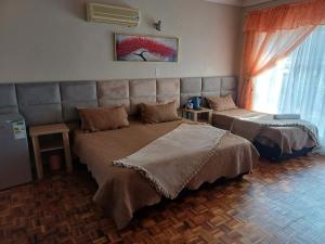 um quarto com duas camas e uma janela em Platinum Guesthouse em Klerksdorp mais 73 fotografias