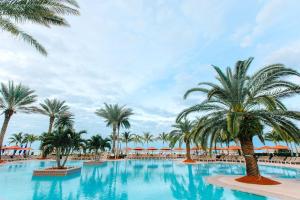 a large swimming pool with palm trees and umbrellas at JW Marriott Marco Island Beach Resort in Marco Island
