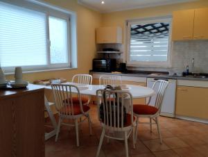 a kitchen with a white table and chairs and a counter at Apartment Rose in Koper