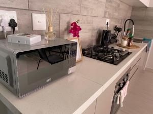 a kitchen counter with a microwave and a stove at 44 Ongwe Self Catering Apartment in Mondesa +5 photos