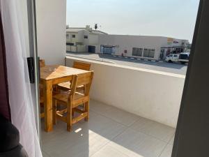 a balcony with a wooden table and a view of a building at 44 Ongwe Self Catering Apartment in Mondesa