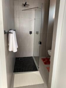 a bathroom with a shower with a glass door at 44 Ongwe Self Catering Apartment in Mondesa