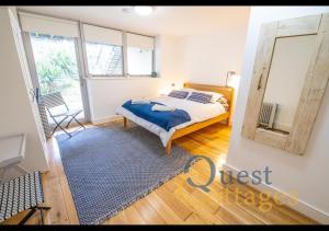 a bedroom with a bed with a blue blanket and a mirror at The Waves - Camber Sands - East Sussex in Camber