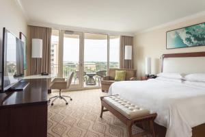 a hotel room with a bed and a desk and a living room at JW Marriott Marco Island Beach Resort in Marco Island