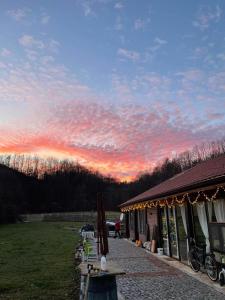 a sunset over a house with a table and a sky at Къща за гости ДворЪ in Skandaloto