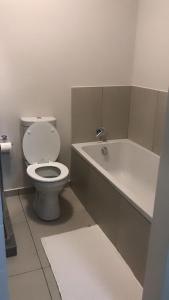 a bathroom with a toilet and a bath tub at Mya Villa 2 in Fourways +2 photos