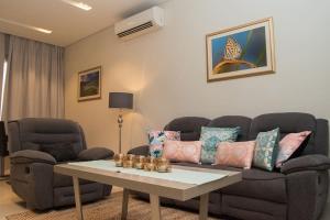 a living room with a couch and a table at Stylish Townhouse Retreat in the Heart of Salalah by Bespoke Holiday Homes in Wādī Khasbar