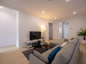 ein Wohnzimmer mit Sofa und Fernseher in der Unterkunft Brand New 4Bs Home near Shops and Park at Greenbank in Greenbank