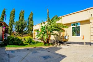 a house with a palm tree in front of it at BEZINDA LODGE in Dodoma