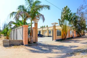 a building with palm trees in front of a street at BEZINDA LODGE in Dodoma +9 photos