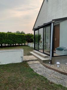 a house with glass doors on the side of it at Maison aux portes de Chambord in Saint-Laurent-des-Eaux