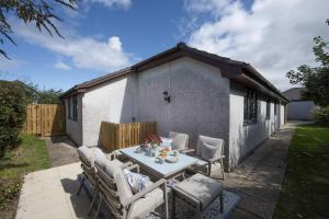 a patio with a table and chairs in a yard at Tre Lowen, Goonhavern, Perranporth - Free Parking - Free Wifi - Games Room in Perranporth