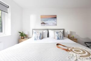 a bedroom with a white bed with blue pillows at Tre Lowen, Goonhavern, Perranporth - Free Parking - Free Wifi - Games Room in Perranporth
