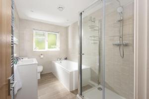 a bathroom with a shower and a tub and a sink at Tre Lowen, Goonhavern, Perranporth - Free Parking - Free Wifi - Games Room in Perranporth +21 photos