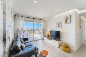 ein Wohnzimmer mit einer blauen Couch und einem Fernseher in der Unterkunft Ocean Garden Sunset View in Adeje