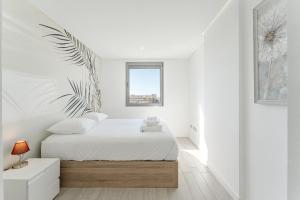 ein weißes Schlafzimmer mit einem Bett und einem Fenster in der Unterkunft Ocean Garden Sunset View in Adeje + 25 Fotos