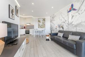 ein Wohnzimmer mit Sofa und eine Küche in der Unterkunft Ocean Garden Sunset View in Adeje