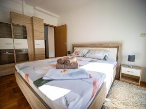 a bedroom with a large bed with towels on it at Apartman Casa di Tasa in Veliko Gradište