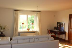 a living room with a white couch and a window at Imagine B&B in Wortegem