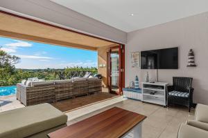 a living room with a sliding glass door to a patio at San Lameer Villa - 14306 - 5 Bedroom Luxury - 10 pax - San Lameer Rental Agency in Southbroom