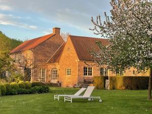 a brick house with a bench in front of it at Imagine B&B in Wortegem