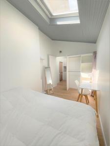 - une chambre avec un lit blanc, une table et des chaises dans l'établissement T3 plein centre proche Versailles Saint Quentin en Yvelines, à Voisins-le-Bretonneux