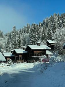 a house covered in snow with a sign in front at Chalet 151Nabor in Les Gets