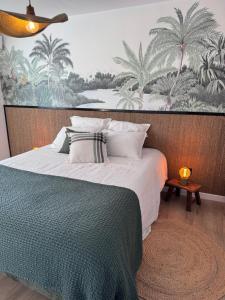 a bedroom with a bed with a painting on the wall at Villa Ô in Les Avirons +62 photos