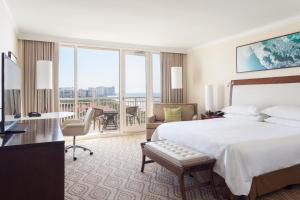 a hotel room with a bed and a desk and a balcony at JW Marriott Marco Island Beach Resort in Marco Island