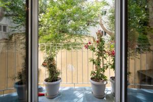 three potted plants sitting on a window sill at 1BR Stylish Apt 20 Minutes from Acropolis in Athens