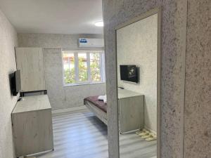 a room with a mirror and a bed and a window at ABS Guest House Osh in Osh
