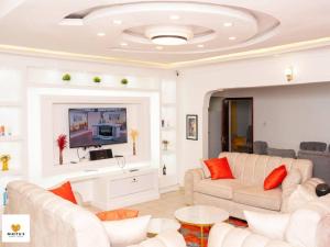 a living room with white furniture and a flat screen tv at Nikita's Serene Home's in Mutet