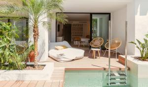 ein Haus mit Swimmingpool im Garten in der Unterkunft Nativo Hotel Ibiza by NCalma Hotels in Santa Eulària des Riu