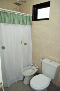 y baño con aseo y cortina de ducha. en Principio de Todo en Ushuaia