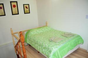 - une chambre avec un lit et une couette verte dans l'établissement Principio de Todo, à Ushuaia