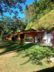 a house with a grass yard in front of it at Chalé Família no Sana - Aconchego e Conforto in Casimiro de Abreu
