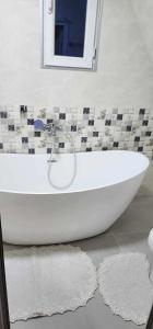 a white bath tub in a bathroom with a mirror at Wildheart in Batumi