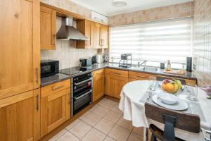 クロイドンにあるChatsworth Ground Floor Apartment!のキッチン(テーブル、フルーツボウル付) +18枚の写真