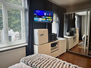 a bedroom with a tv on the wall and a bed at Lux Akinle Residence in Nottingham +16 photos