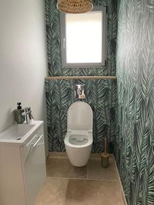 a bathroom with a toilet and a sink and a window at La Villa Atea in Joue-les-Tours