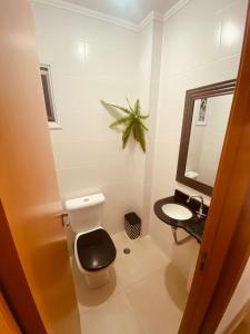 a bathroom with a toilet and a sink at Apartamento morada morada do sol 208 in Ubatuba