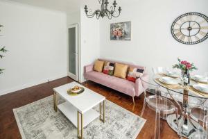クロイドンにあるChatsworth Ground Floor Apartment!のリビングルーム(ピンクのソファ、ガラスのテーブル付)