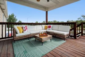 a porch with a couch and a table on a deck at Charming 5BD - UNL 5mins - BBQ, Games & Backyard in Arbor