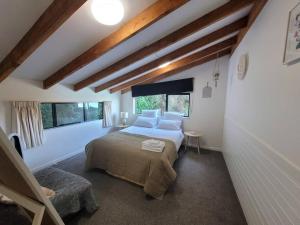 a bedroom with a bed and two windows at Waterfront 8 bedroom home with hot tub and mooring in French Farm