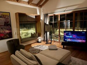 a living room with a couch and a flat screen tv at Sonnberg Chalet - Entspannung pur im Luxus Chalet mit Whirlpool-Sauna in Lachtal