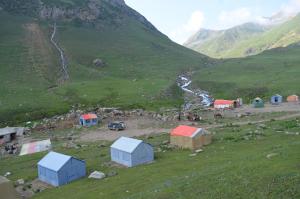 a group of huts on a mountain with a river at Outdoor Adventures Camp Ratti Gali Lake in Shardi